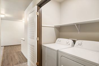 A washer and dryer in a laundry room with a door to the closet